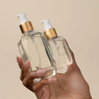Hand holding luxury hair serum bottles for hair extensions in Delray Beach FL, Signature Extensions.