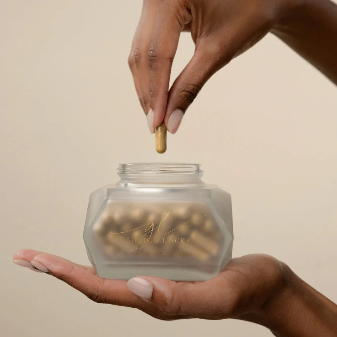 Hand holding Goldie Locks hair care supplement jar for hair transformation in Delray Beach FL